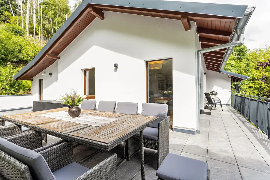 Sonnenterrasse des Chalets mit Esstisch und Blick ins Grüne