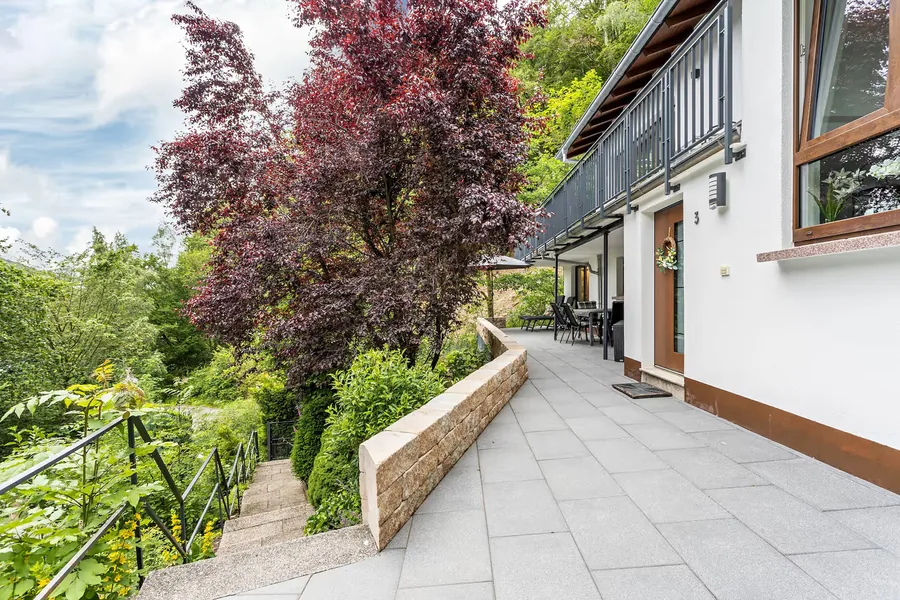 Das Chalet von außen: Terrasse im Erdgeschoss, Balkon darüber, zwei getrennte Eingänge